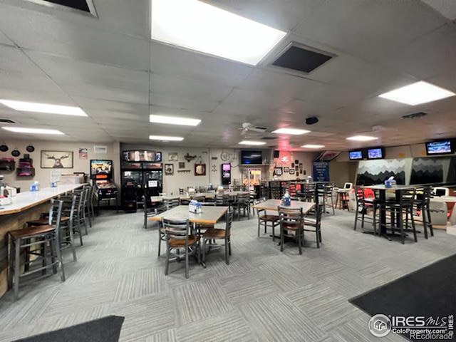 carpeted dining room with a drop ceiling