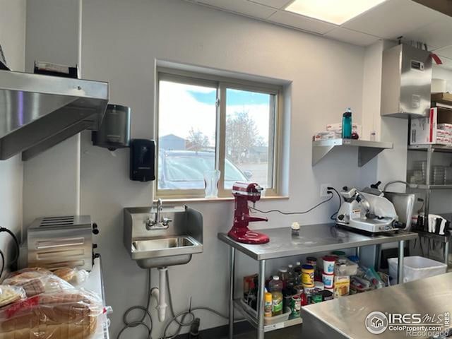 kitchen with a drop ceiling, sink, and stainless steel counters