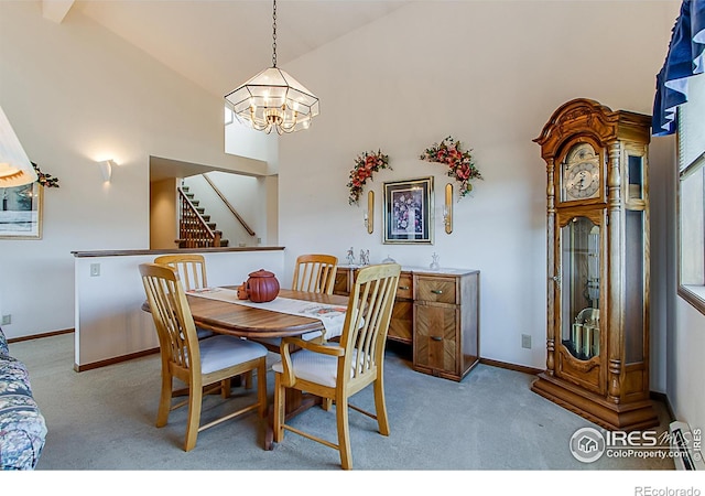 dining space featuring light colored carpet, a chandelier, and high vaulted ceiling