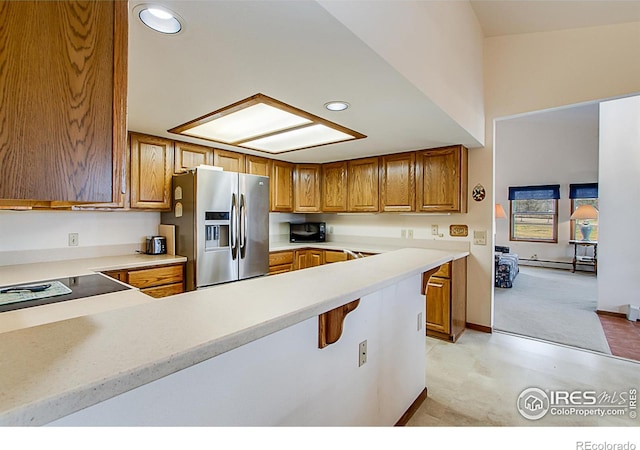 kitchen featuring kitchen peninsula, stainless steel refrigerator with ice dispenser, and baseboard heating