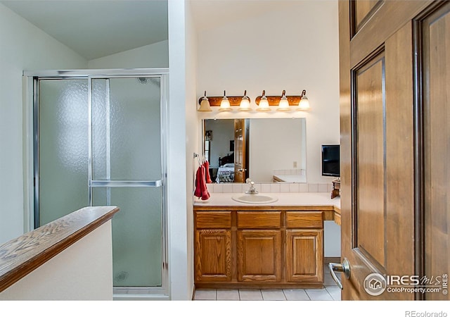 bathroom featuring tile patterned floors, a shower with shower door, lofted ceiling, and vanity