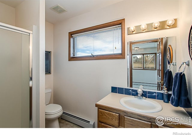 bathroom with vanity, toilet, a wealth of natural light, and a baseboard heating unit