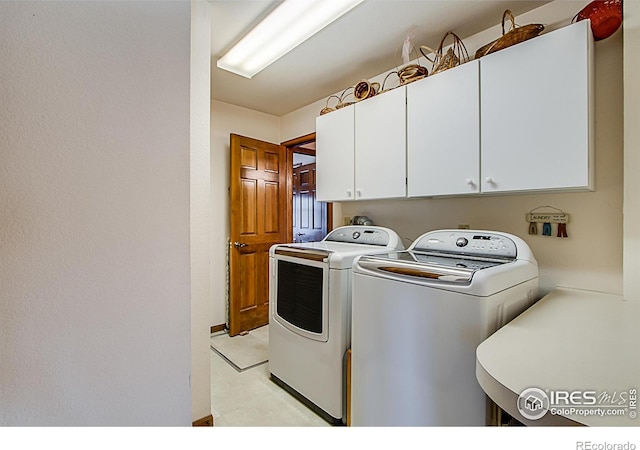 laundry area with washing machine and dryer and cabinets