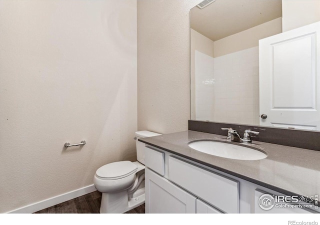 bathroom with hardwood / wood-style floors, vanity, and toilet