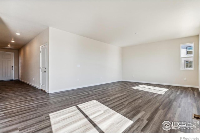 spare room with dark wood-type flooring