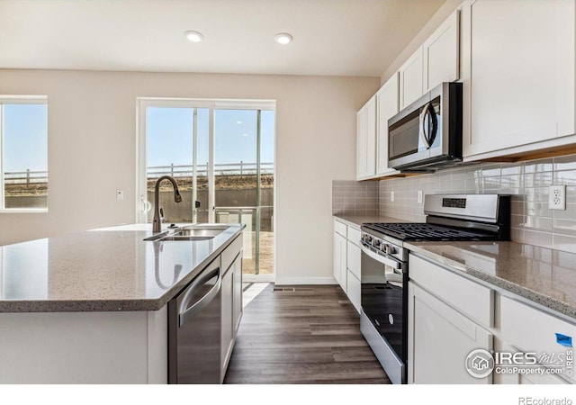 kitchen with white cabinets, appliances with stainless steel finishes, dark hardwood / wood-style flooring, and a wealth of natural light