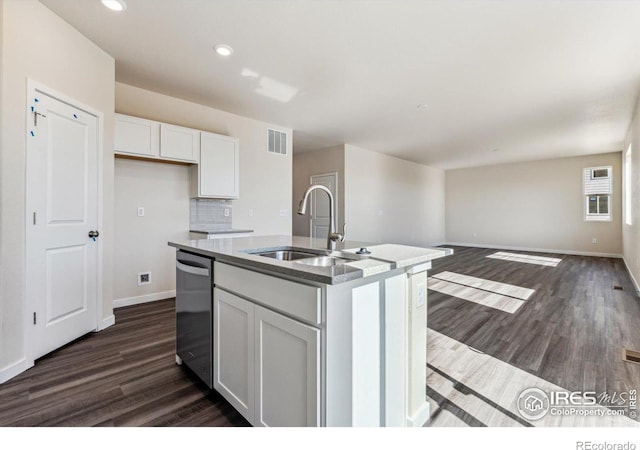 kitchen with a kitchen island with sink, sink, stainless steel dishwasher, dark hardwood / wood-style flooring, and white cabinetry