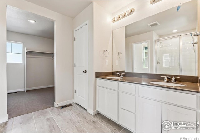 bathroom with vanity and a shower with door