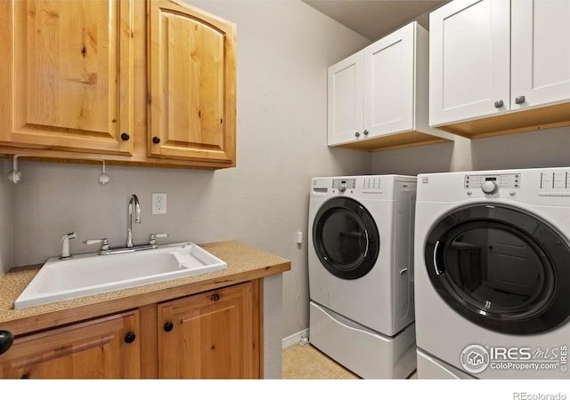 laundry area with sink, separate washer and dryer, and cabinets