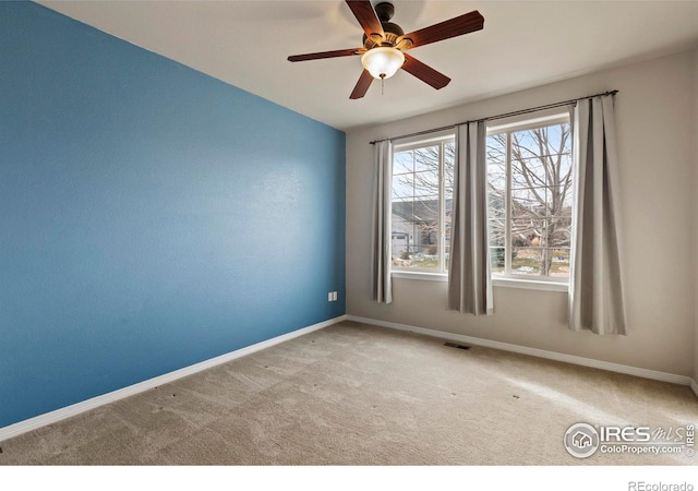 carpeted spare room featuring ceiling fan