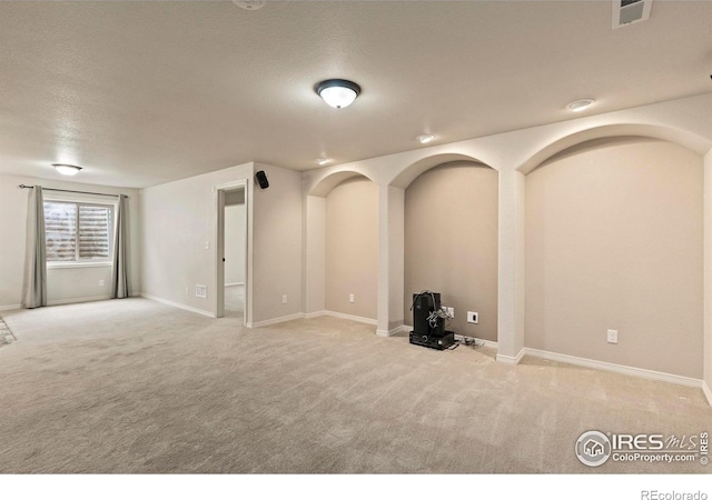 interior space with a textured ceiling and light colored carpet