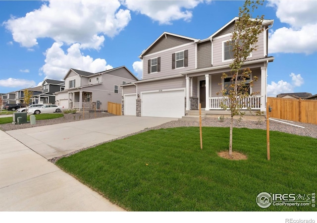 view of front of home with a front lawn, covered porch, and a garage