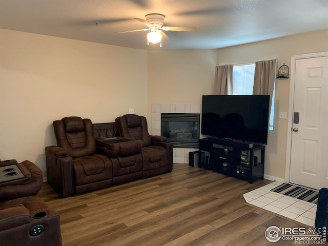 living room with hardwood / wood-style flooring, ceiling fan, and a fireplace