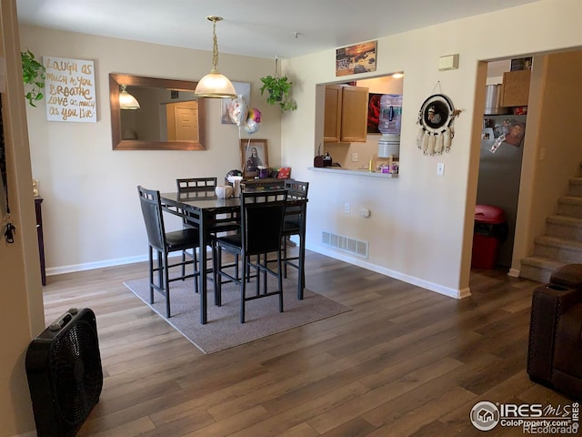 dining space with dark wood-type flooring