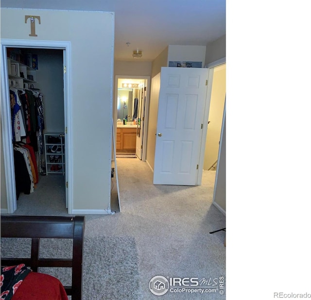 hallway featuring light colored carpet