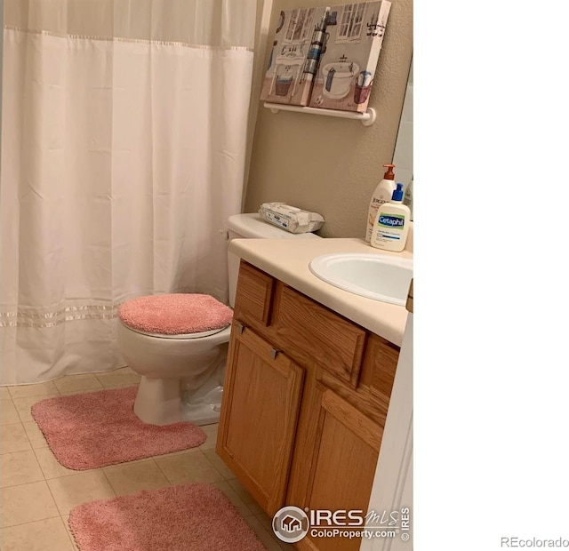 bathroom featuring tile patterned flooring, vanity, and toilet