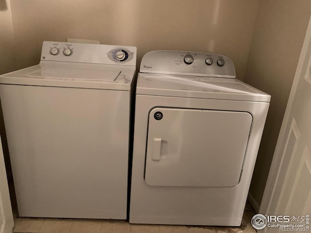 laundry area featuring light tile patterned floors and washing machine and clothes dryer