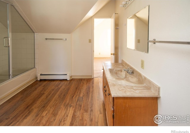 bathroom with combined bath / shower with glass door, wood-type flooring, vanity, and baseboard heating