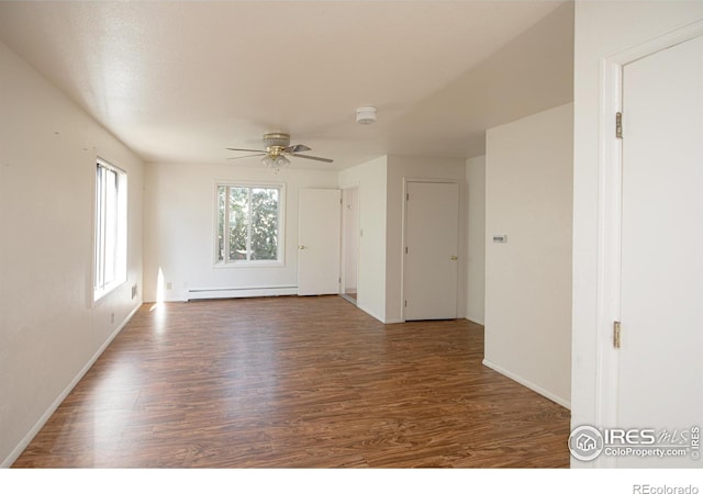 unfurnished room with a baseboard heating unit, ceiling fan, and dark wood-type flooring