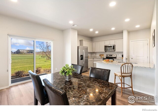 dining area featuring light hardwood / wood-style floors and sink