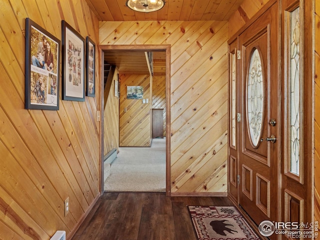 foyer featuring wood walls, dark wood-type flooring, and wooden ceiling