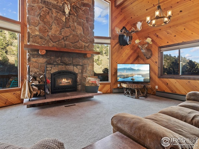 carpeted living room featuring wooden walls, a wealth of natural light, a high ceiling, and a baseboard heating unit