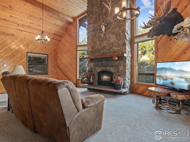 carpeted living room with wood walls, wooden ceiling, a fireplace, and high vaulted ceiling