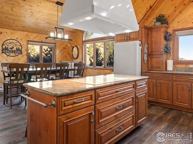 kitchen with custom exhaust hood, lofted ceiling, wooden walls, black electric cooktop, and white fridge