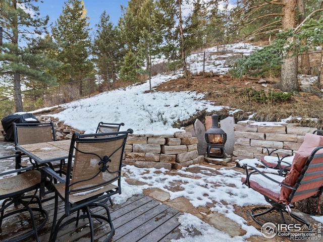 snow covered patio featuring a grill