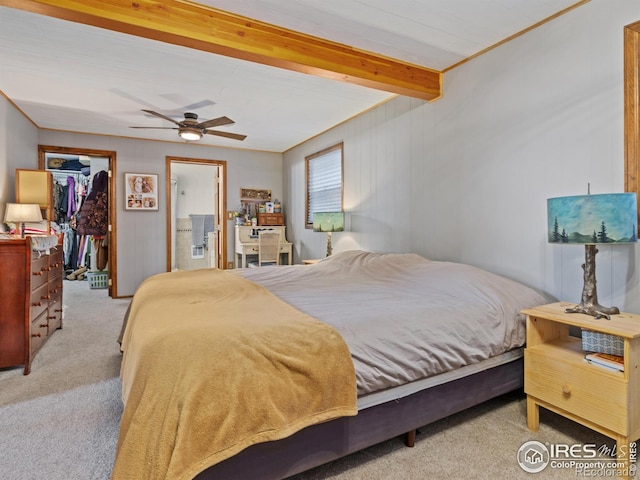 bedroom with light carpet, ceiling fan, beam ceiling, a spacious closet, and a closet