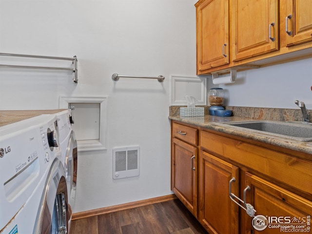 laundry room featuring cabinets, dark hardwood / wood-style flooring, heating unit, sink, and washer and dryer