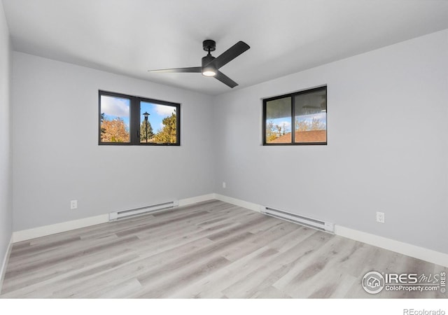 unfurnished room with plenty of natural light, light hardwood / wood-style floors, and a baseboard heating unit