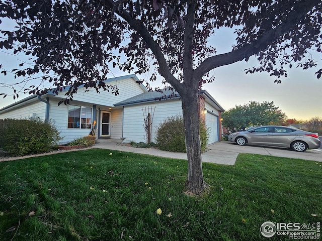 view of front of home with a yard and a garage