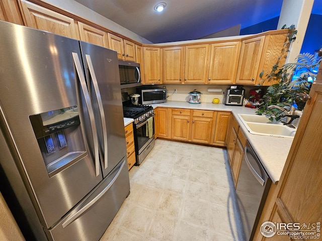 kitchen with sink, stainless steel appliances, and vaulted ceiling