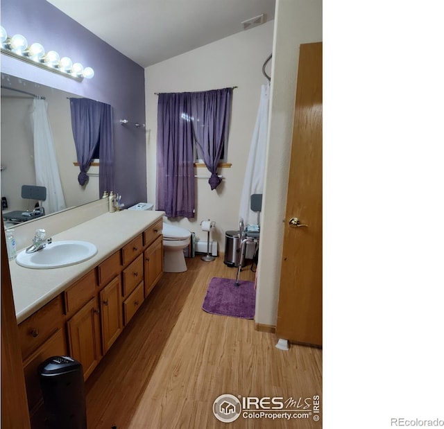 bathroom with hardwood / wood-style floors, vanity, and toilet