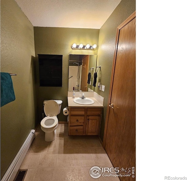 bathroom with toilet, vanity, a textured ceiling, and a baseboard heating unit