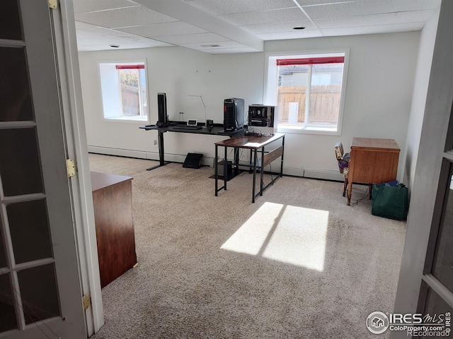 carpeted office featuring a baseboard radiator, a drop ceiling, and a healthy amount of sunlight