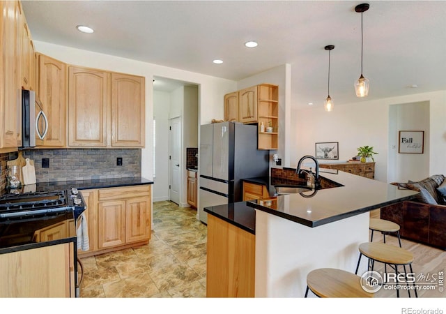 kitchen featuring hanging light fixtures, light brown cabinetry, sink, and stainless steel appliances