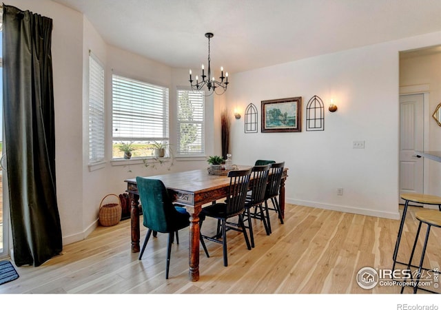 dining area featuring light hardwood / wood-style flooring and an inviting chandelier