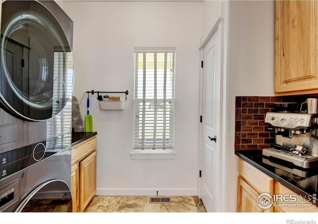 laundry area featuring stacked washer and dryer