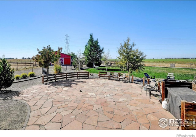 view of patio featuring a rural view and an outbuilding