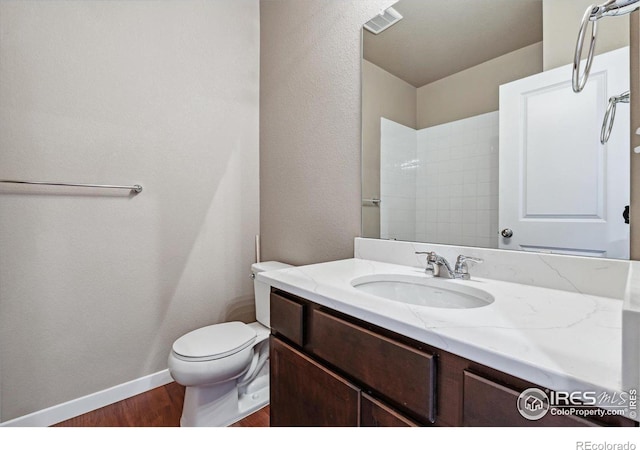 bathroom featuring vanity, wood-type flooring, and toilet