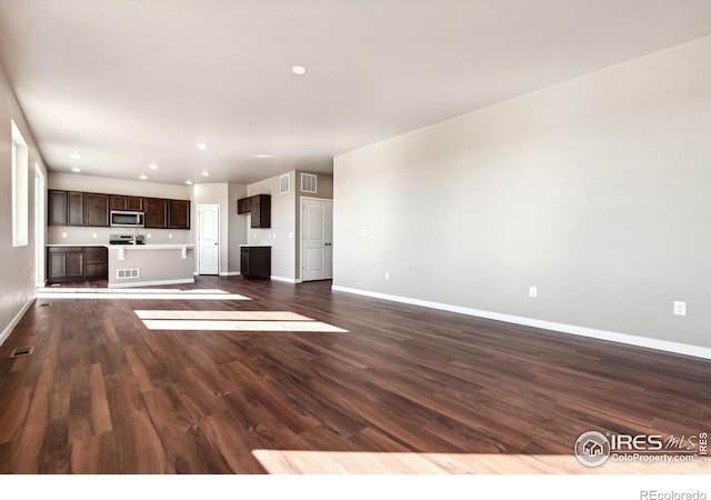 unfurnished living room with dark wood-type flooring