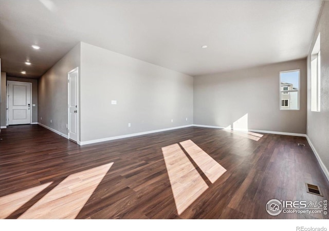 spare room featuring dark wood-type flooring