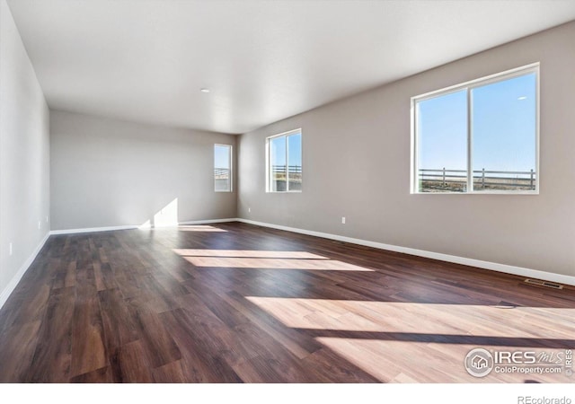 unfurnished room with dark hardwood / wood-style flooring