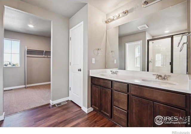 bathroom featuring wood-type flooring, vanity, and a shower with door