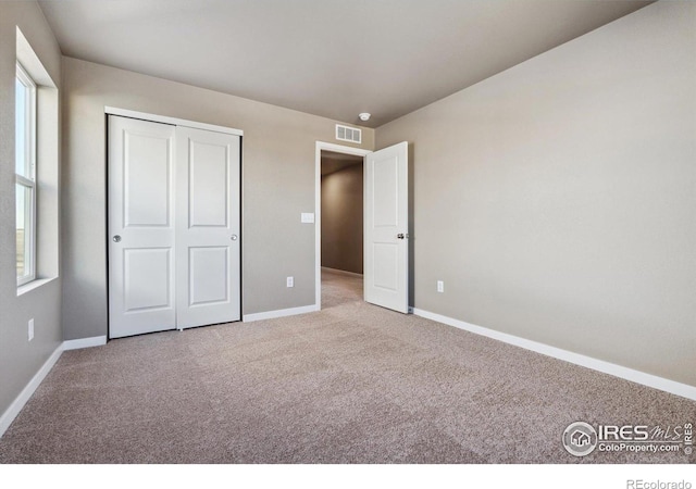 unfurnished bedroom featuring carpet floors and a closet