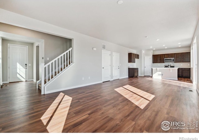 unfurnished living room featuring dark wood-type flooring