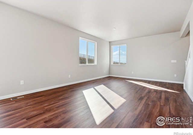 unfurnished room with dark hardwood / wood-style flooring