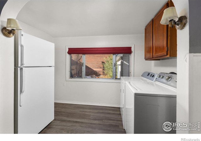 clothes washing area with cabinets, washer and clothes dryer, and dark wood-type flooring